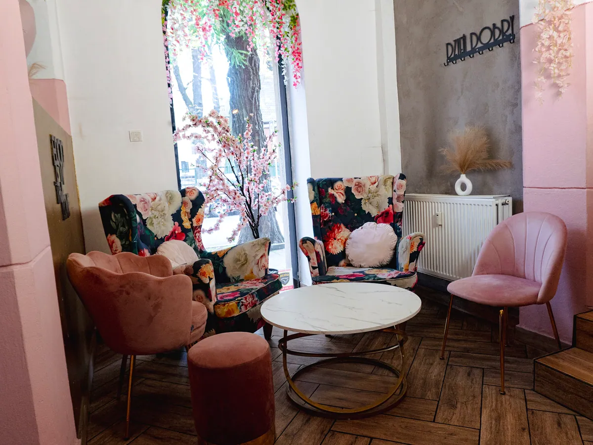 Różowe fotele i kwiecista sofa przy oknie w Same Maszkety